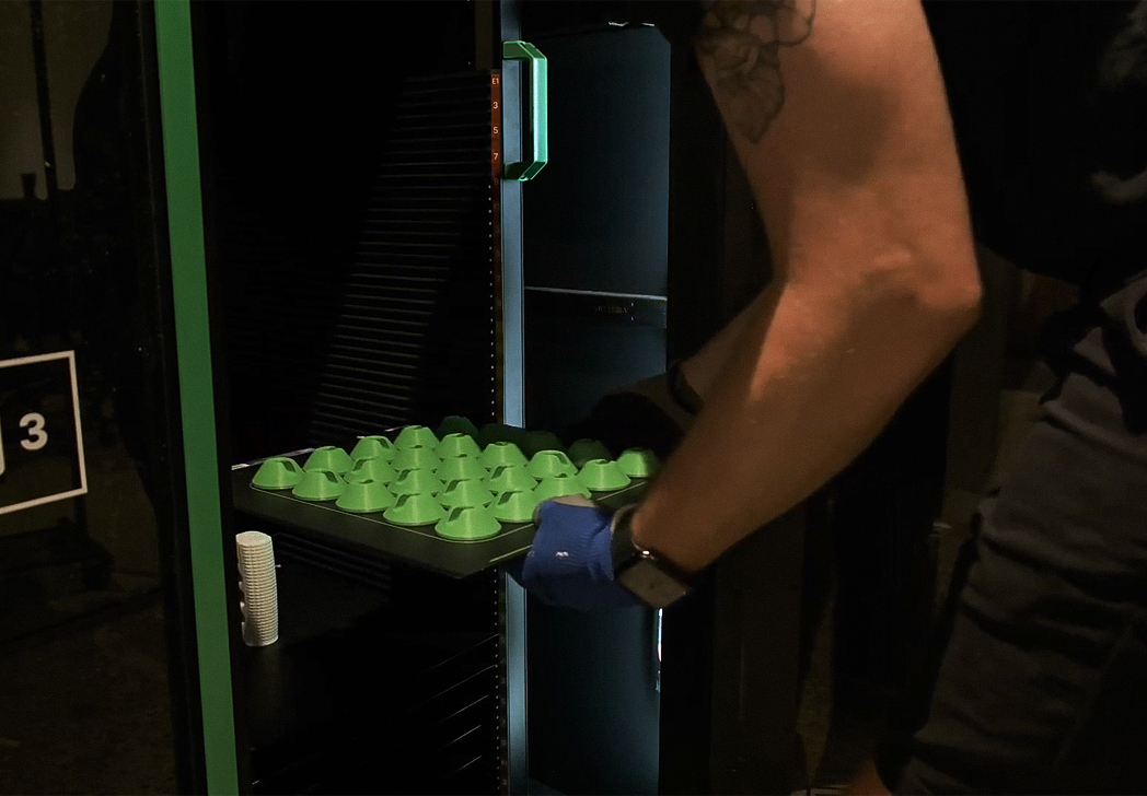 Medical professional taking out a Print Bed filled with 3D printed parts out of Mosaic's Array