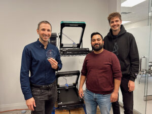 Mosaic Manufacturing Wins Best in Digital Showcase at AOPA 2026 1 Mosaic Manufacturing leadership standing in front of Orion 3d printer with AOPA award